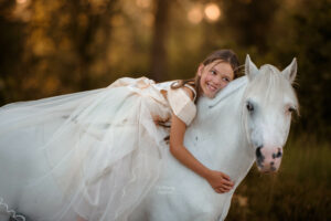 meisje met witte prinsessen jurk op een witte pony
