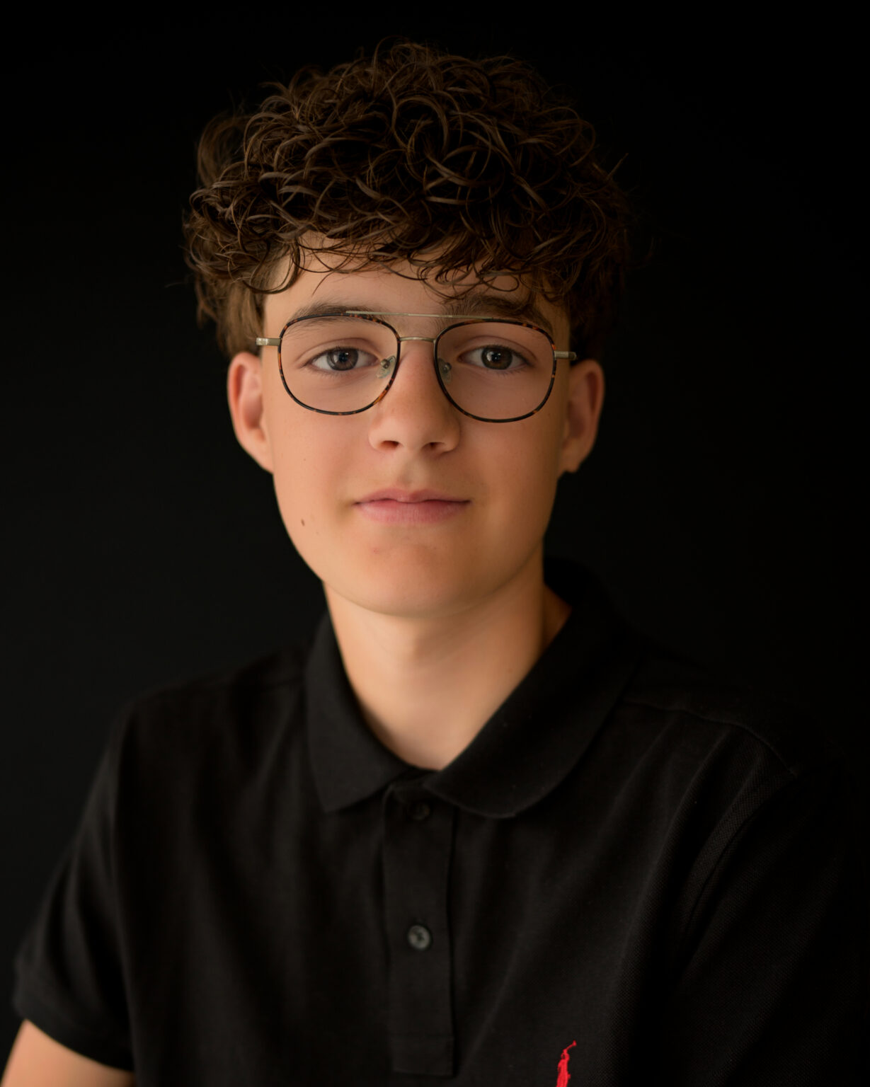 Portret jongen met krullen en bril
