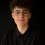 Portret jongen met krullen en bril