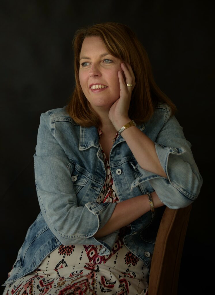 Vrouw in spijkerjasje kijkt opzij in zacht belicht studioportret door PictureByCarlina